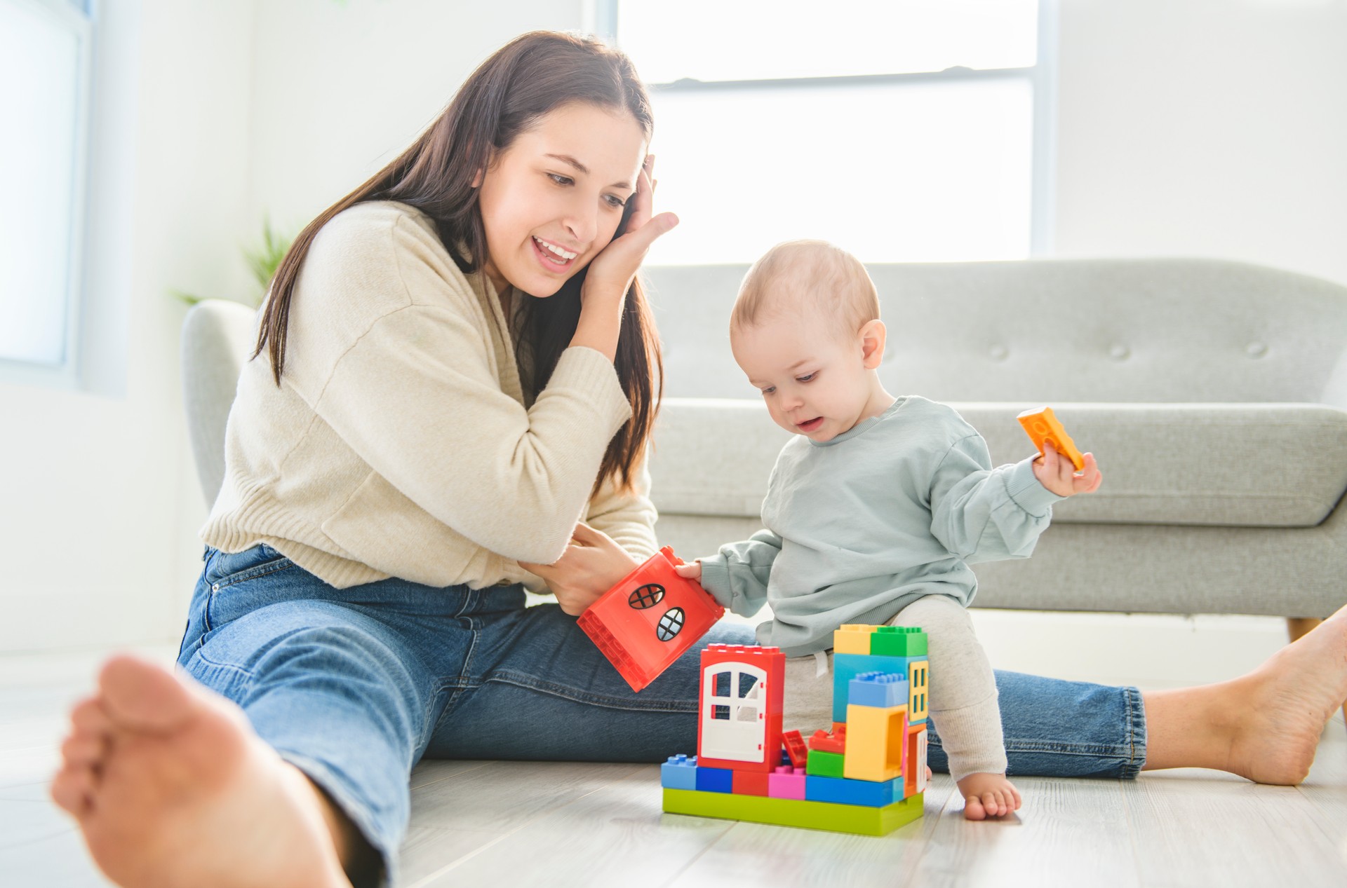 mother plays with her son with toy block at home